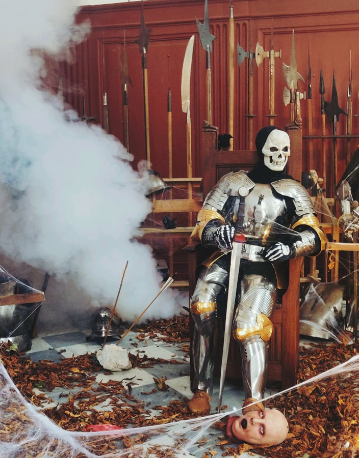 photographie d'un squelette en armure et entouré d'armes anciennes dans une salle du château